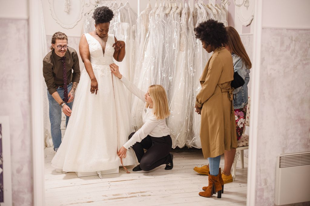 Designer making adjustment to bridal gown