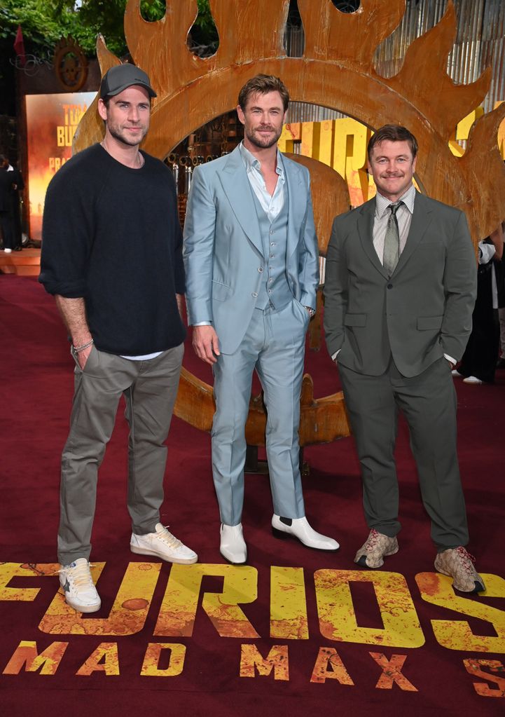 Liam Hemsworth standing with Chris and Luke Hemsworth