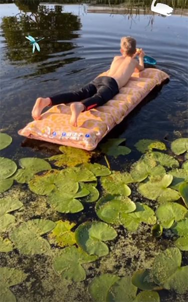 Young boy on a lilo on a pond