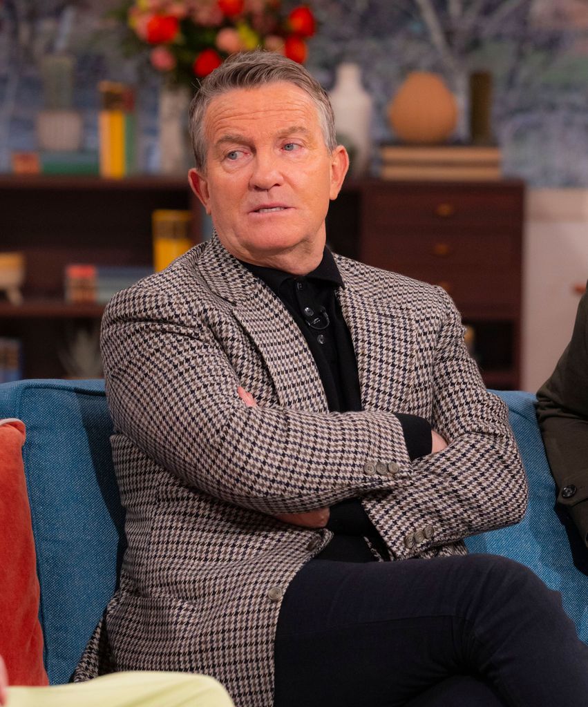 man sat cross armed on chair 