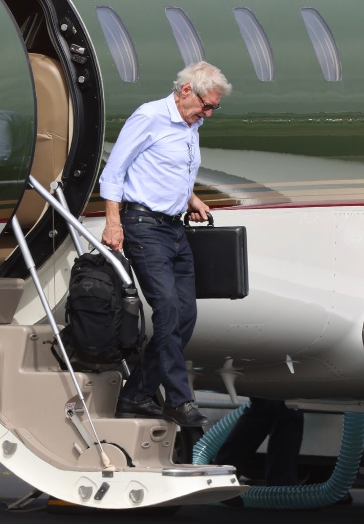 Harrison Ford seen walking down steps of his plane after arriving at LAX Airport one month after canceling his Oscars appearance due to a shingles diagnosis 
