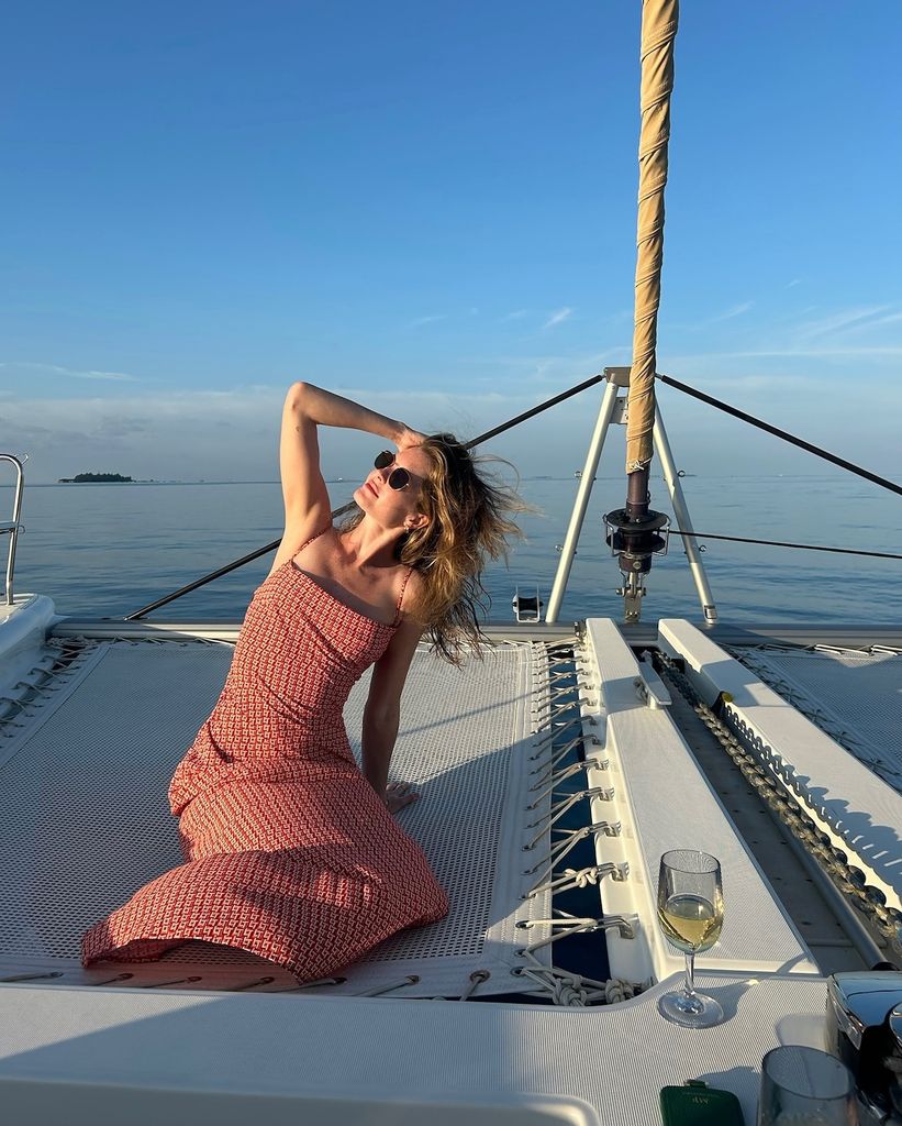 woman posing on boat in red dress 