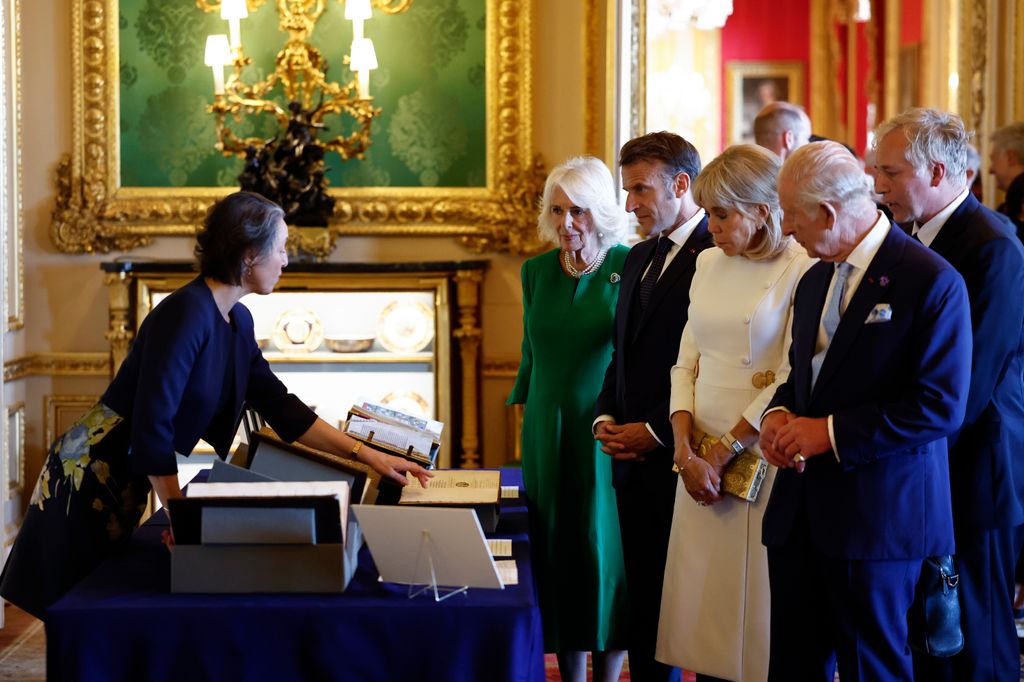  France's President Emmanuel Macron and his wife Brigitte Macron, alongside Britain's King Charles III and Britain's Queen Camilla, view an exhibition of art from the Royal Collection exhibition, in the Green Drawing Room at Windsor Castle
