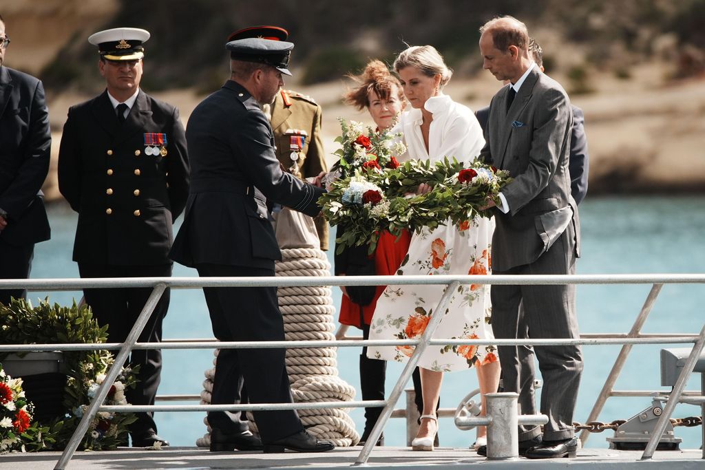 Sophie deixando cair coroas de flores no barco