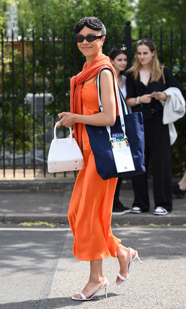 India Amarteifio took style cues from Lila Moss and wore a satin slip dress with a matching jumper wrapped around her shoulders. She paired with white sandals and a white bag from Aspinal of London.