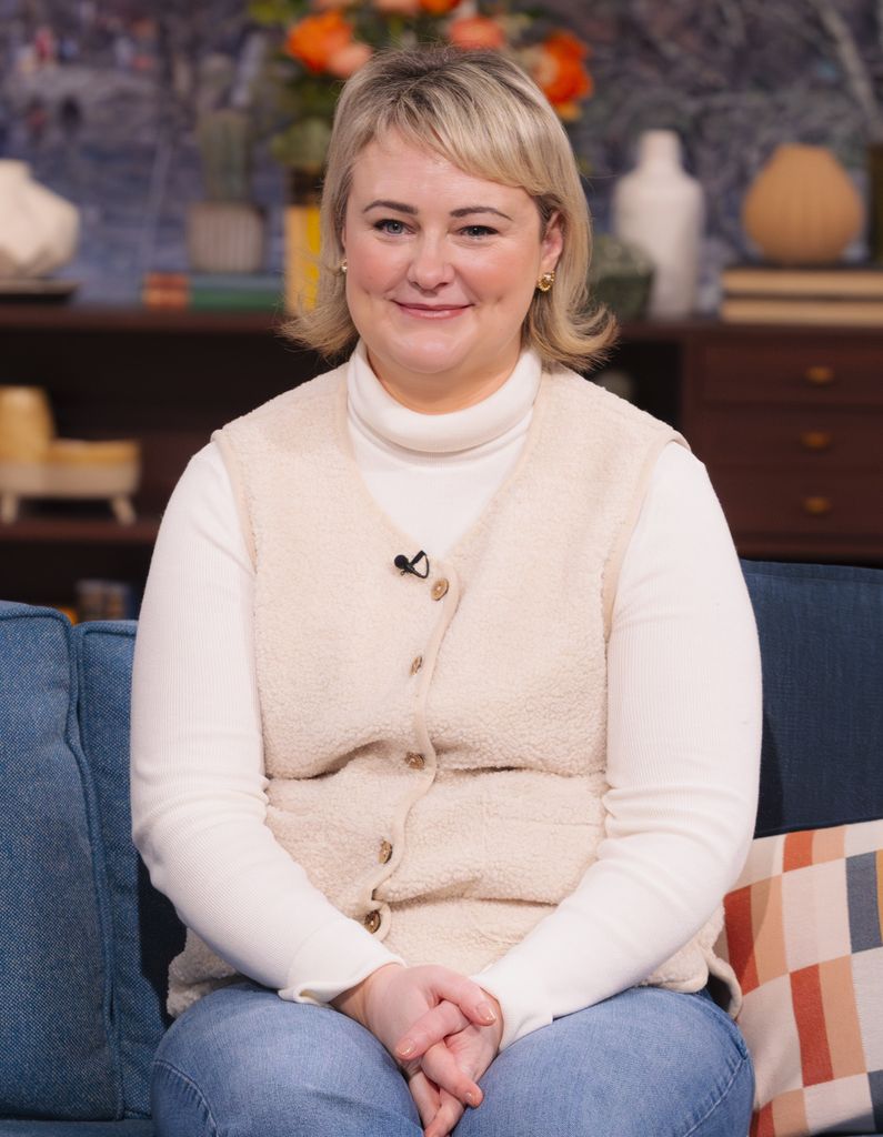 Philippa Dunne sitting on a sofa in a cream outfit