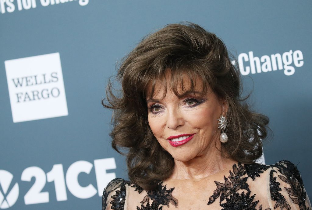 joan collins smiling in black lace dress 