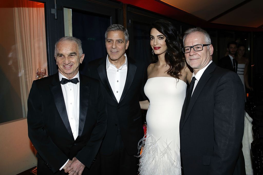 Amal en robe blanche entre George Clooney, Alain Terzian et Thierry Fremaux en costumes
