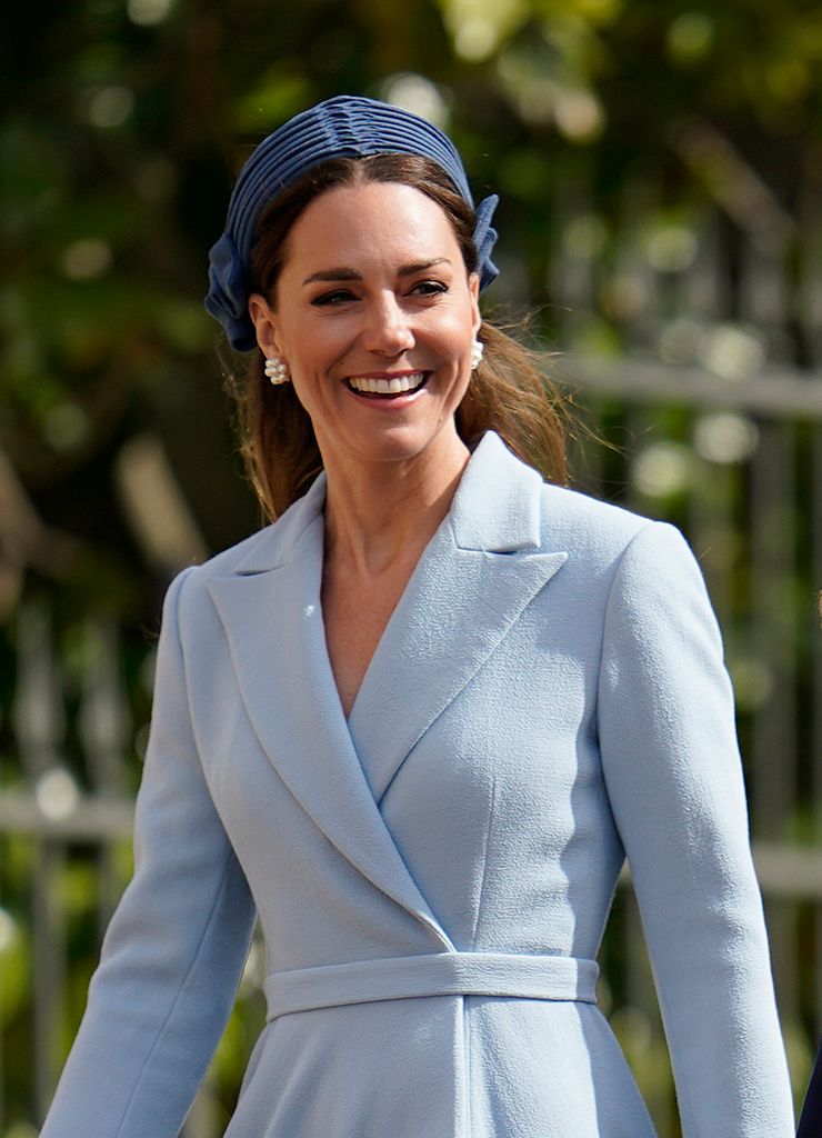 Catherine in light blue coat dress and headband smiling