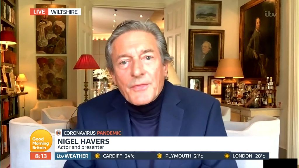 Ngel Havers sitting in a room surrounded by paintings