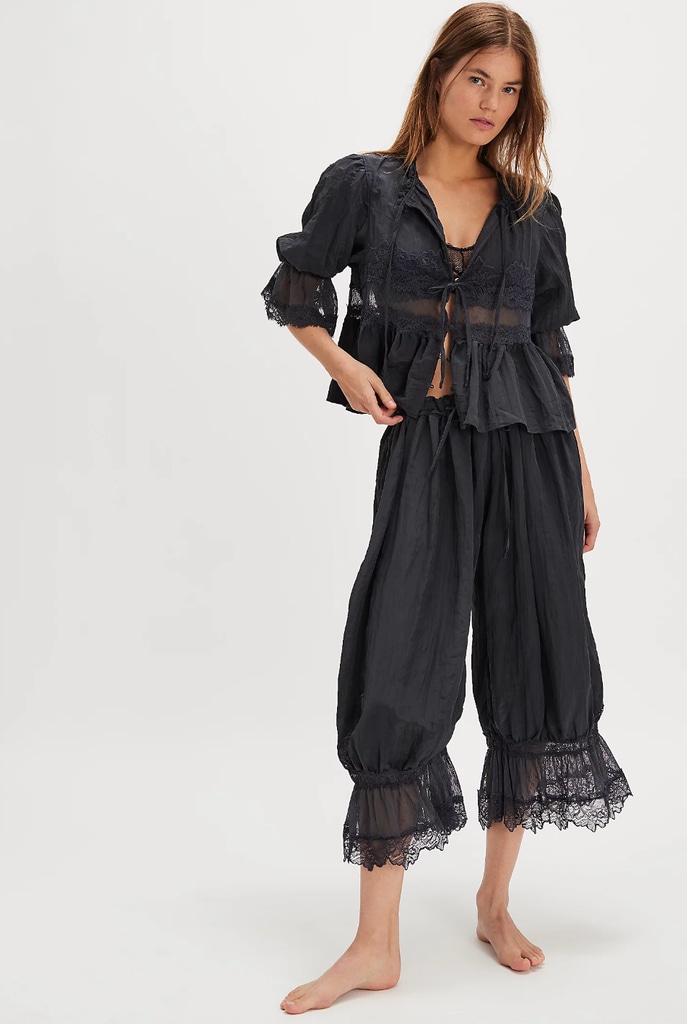 A model poses in black trousers and a black top