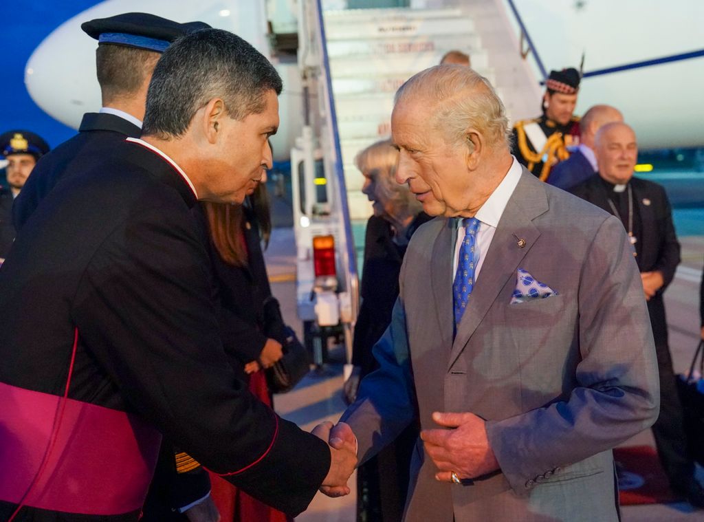 King Charles shaking hands with a man from the Vatican