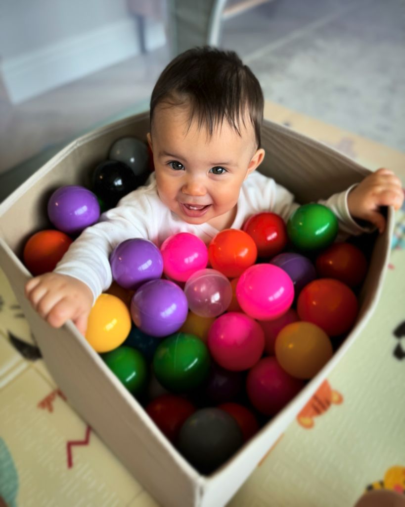 baby girl playing in small ball pit