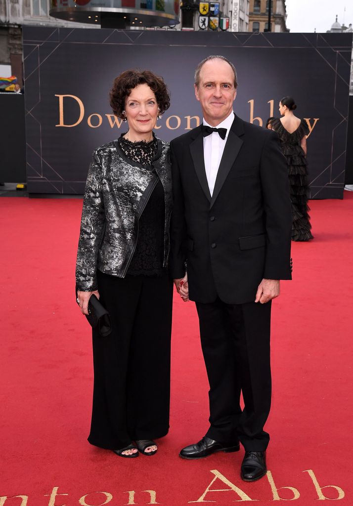 Woman and man holding hands on red carpet