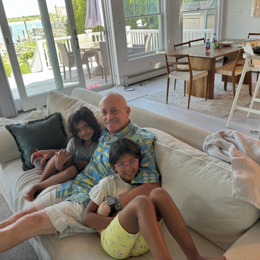 Joel Schiffman cuddles with his daughter Haley and Hope on a sofa 