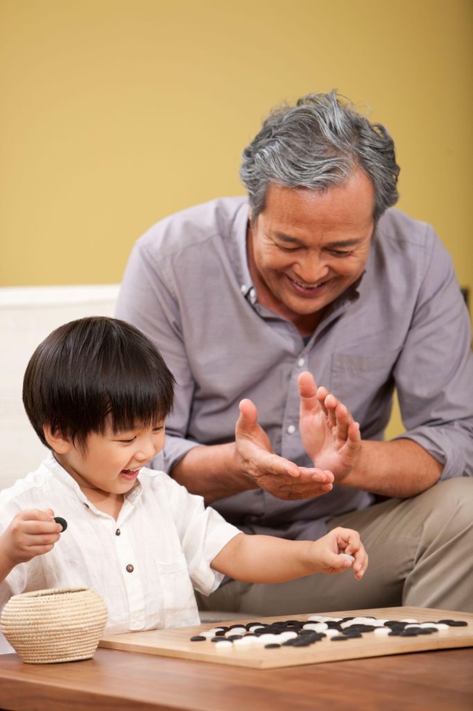 Un grand-père qui regarde son petit-fils jouer