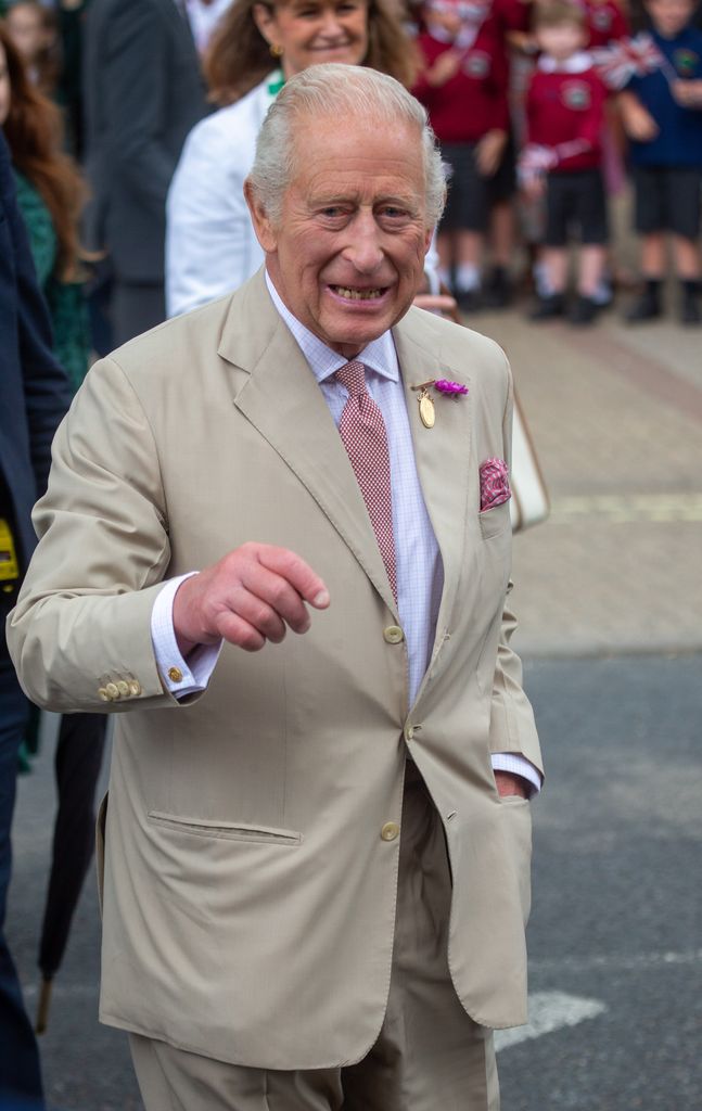 King Charles in camel suit smiling