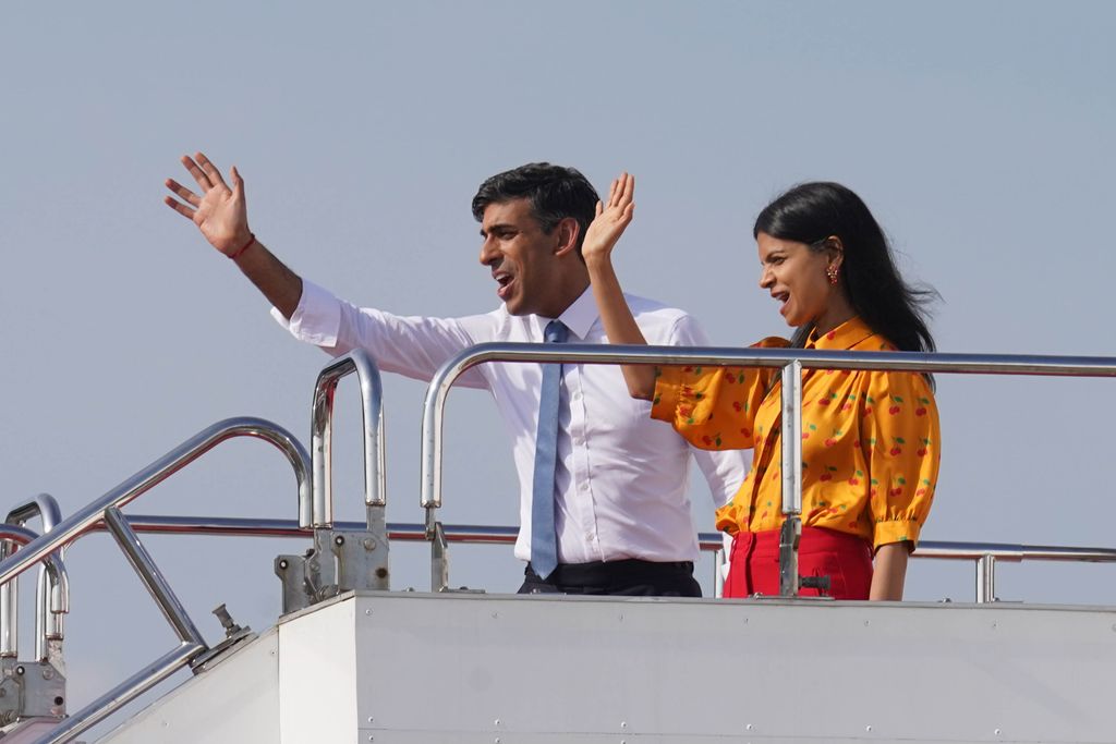 British Prime Minister Rishi Sunak and wife Akshata Murty wave as they board a plane in Hiroshima, after the G7 Summit on May 21, 2023 in Hiroshima, Japan.