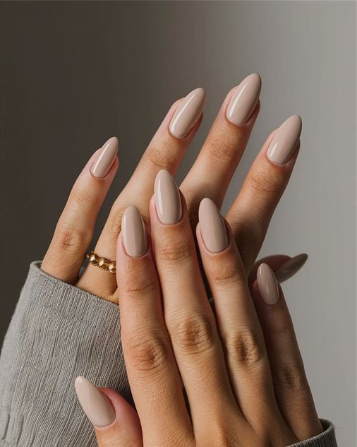Solid light beige manicure with a clean, polished porcelain skin finish on medium length nails