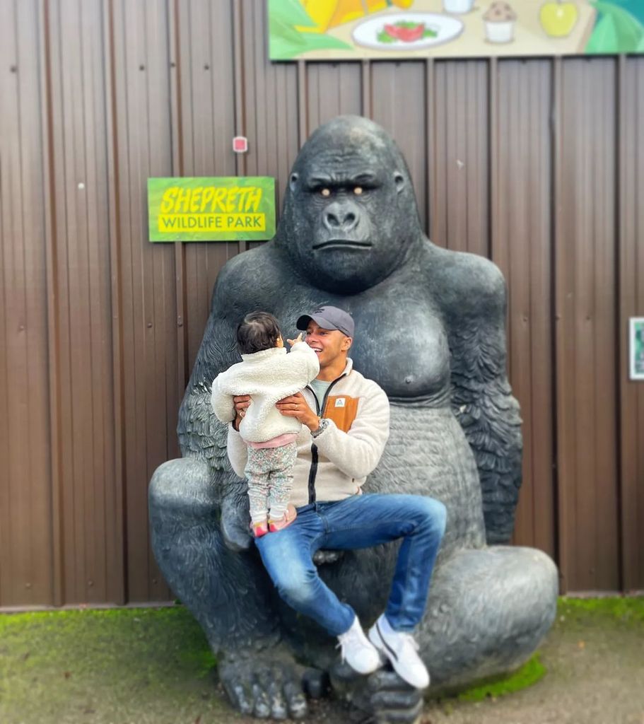 Will Kirk posing with daughter on a giant gorilla statue