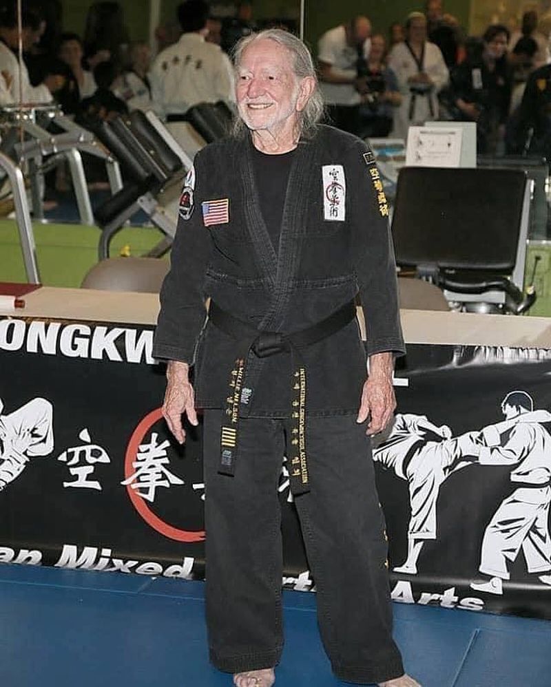 Musician Willie Nelson is presented with his 5th Degree Black Belt in the art of Gong Kwon Yu Sul by Grand Master Sam Um (R) at his studio Master Martial Arts on April 28, 2014 in Austin, Texas.