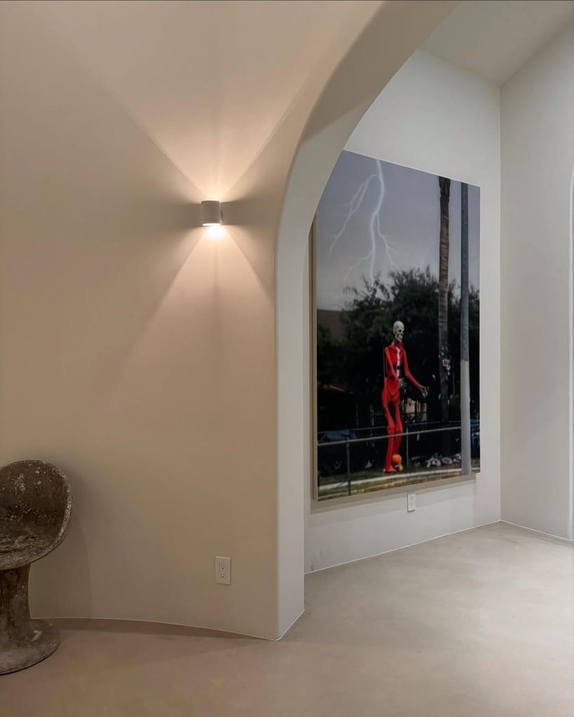 Framed artwork on white wall in hallway of Kourtney Kardashian's home