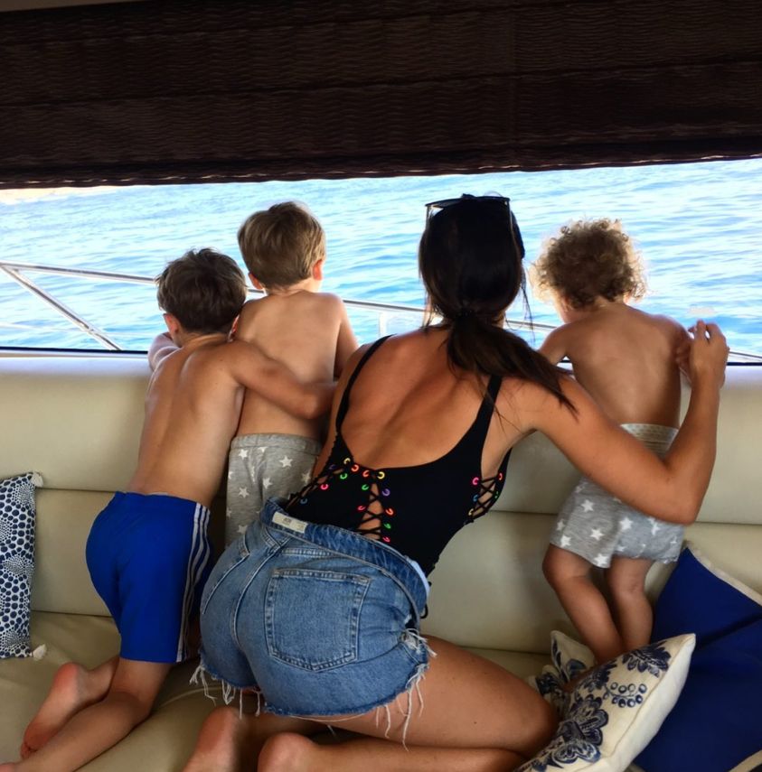 Back of Annie Kilner and three boys on a boat