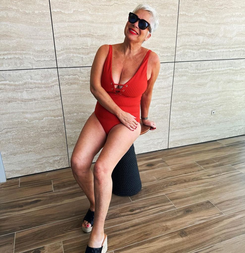Denise Welch smiling in an orange swimsuit 