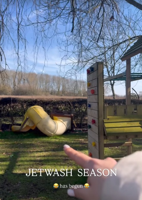 Stacey points to a slide next to the climbing frame in her garden with field in the background