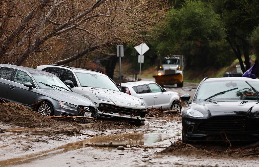 Vehicles damaged by flooding remain stuck as a powerful long-duration atmospheric river storm, near Malibu, California