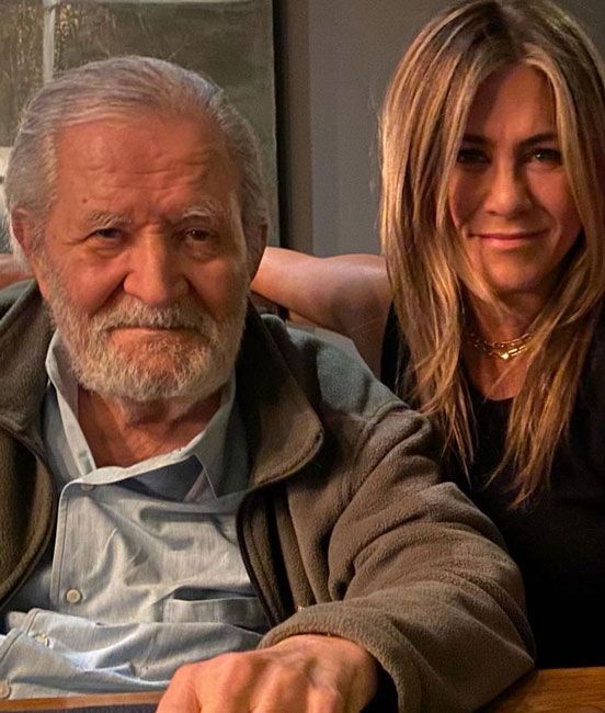 jennifer puts her arm around her fathers shoulder for a photo