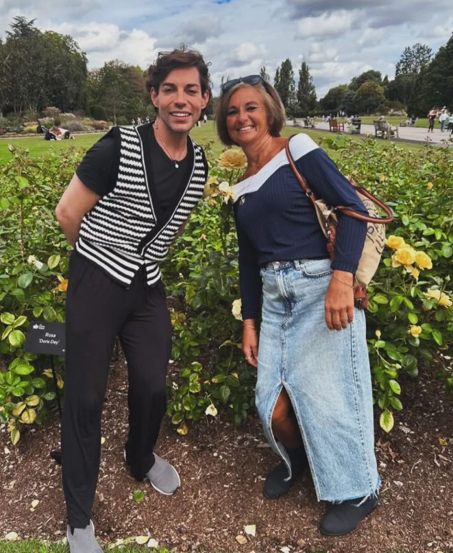Tom Read Wilson and his mother standing in front of a field of flowers