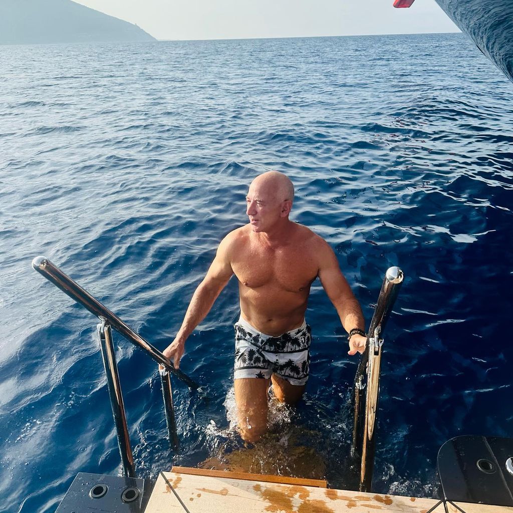 jeff bezos climbing onto yacht