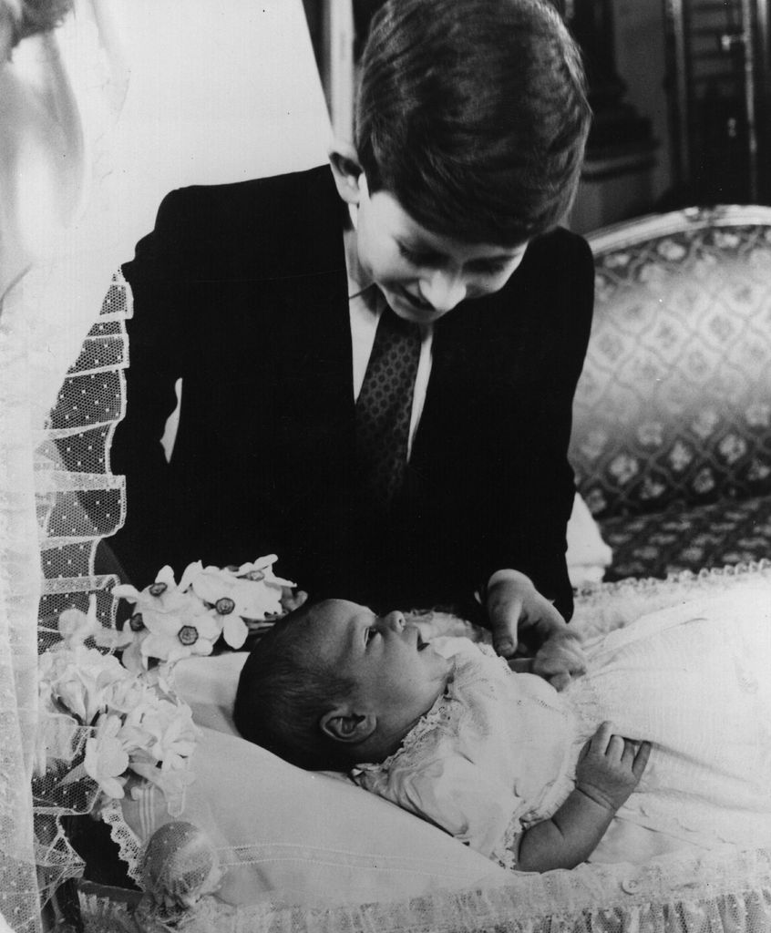 A young Prince Charles looking down on Prince Andrew as a baby