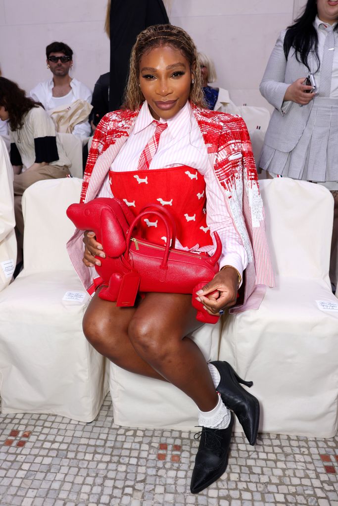 Serena Williams sitting in red look with a dog-shaped bag