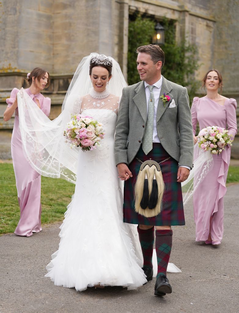 bride and groom with bridesmaids behind