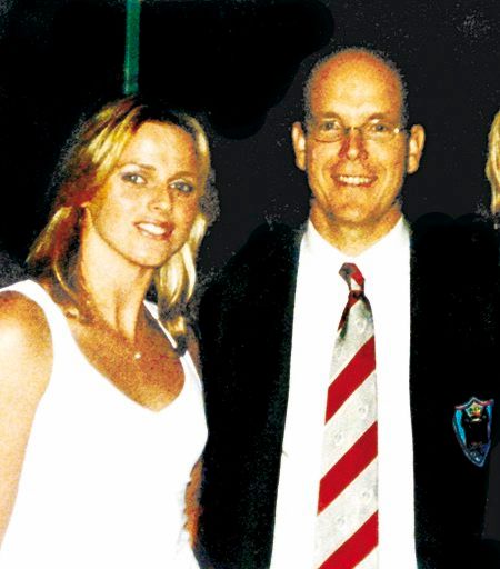 Grainy photo of Princess Charlene in a white outfit and Prince Albert in a black suit jacket and red and white striped tie