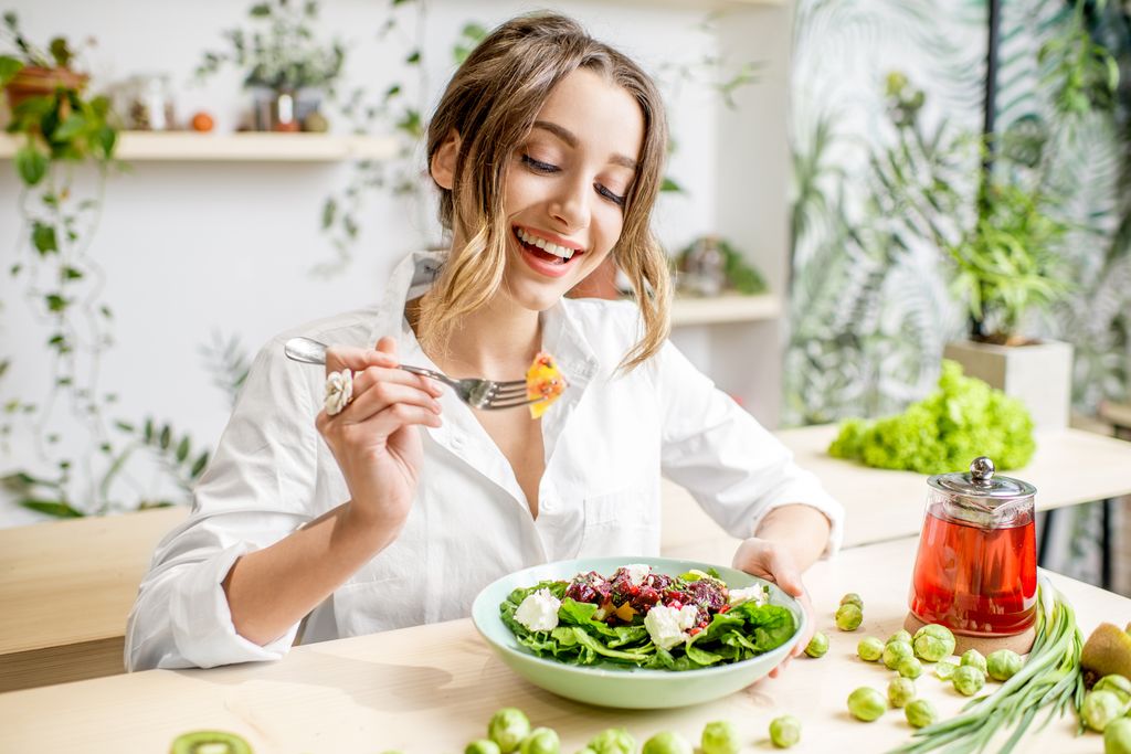 Woman eating salad looking happy