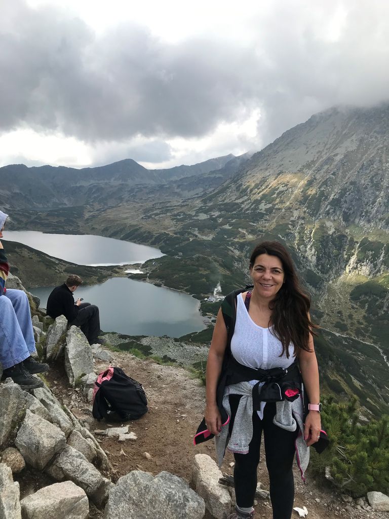 Woman hiking up a mountain in a white top