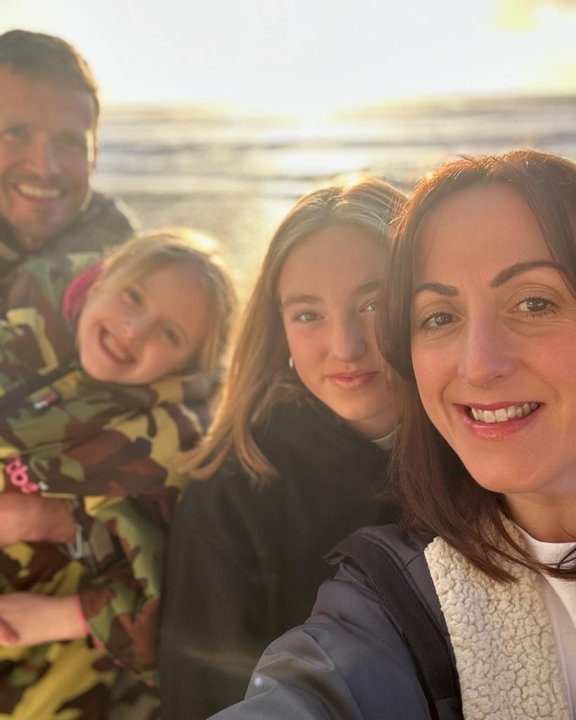 Natalie Cassidy with her fiancé and two daughters on the beach