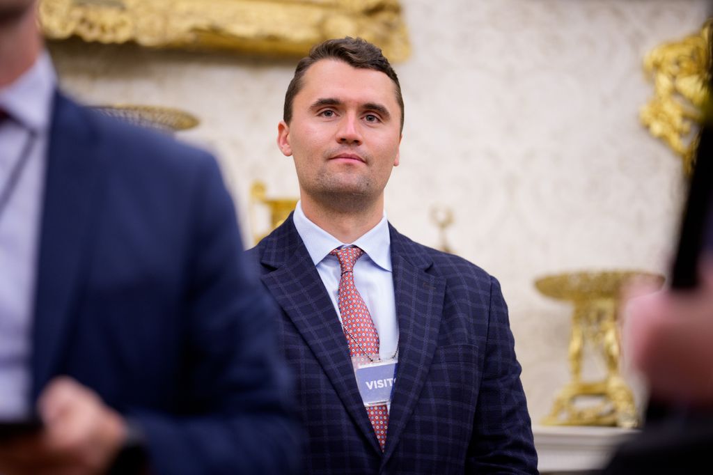 Turning Point USA co-founder Charlie Kirk stands in the back of the room as U.S. President Donald Trump speaks during a swearing in ceremony for interim U.S. Attorney for Washington, D.C. Jeanine Pirro in the Oval Office of the White House on May 28, 2025 in Washington, DC. Trump has announced Pirro, a former Fox News personality, judge, prosecutor, and politician, after losing support in the Senate for his first choice, Ed Martin, over his views on the January 6, 2021 attack on the U.S. Capitol.