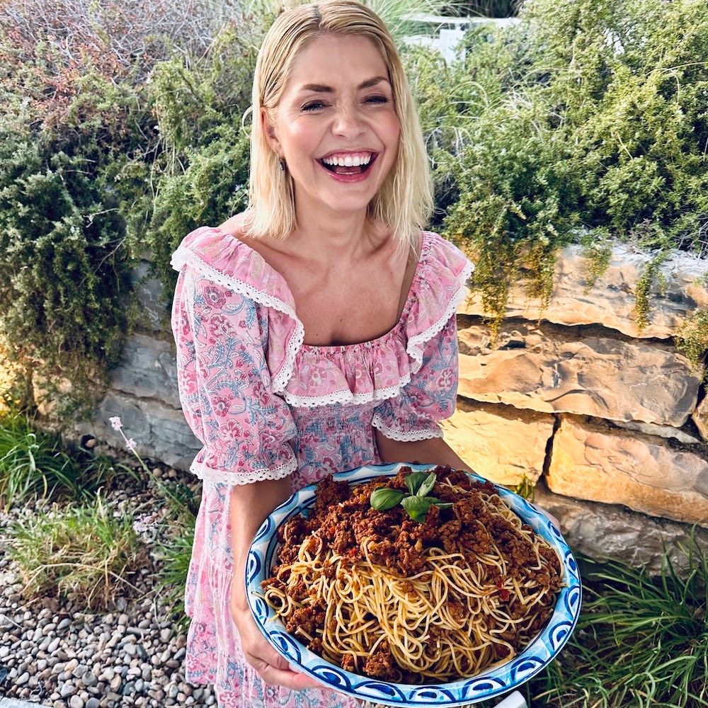 Holly Willoughby laughing and holding plate of pasta 