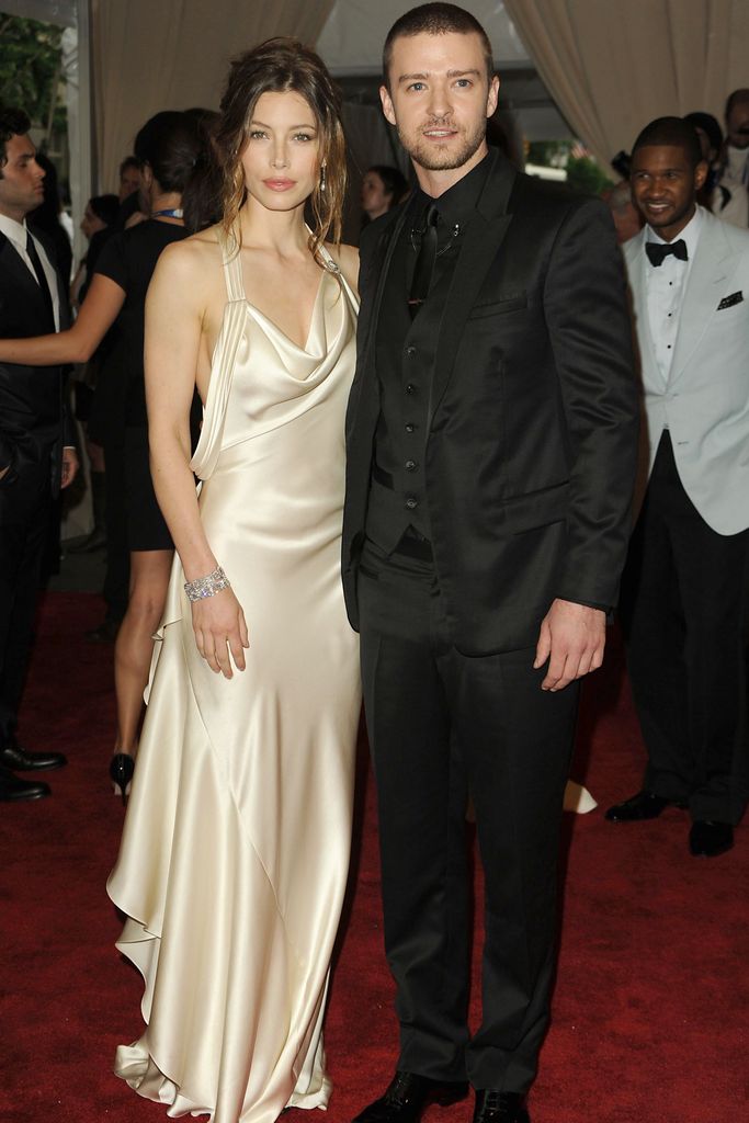 Jessica Biel em vestido de seda creme e Justin Timberlake em terno preto