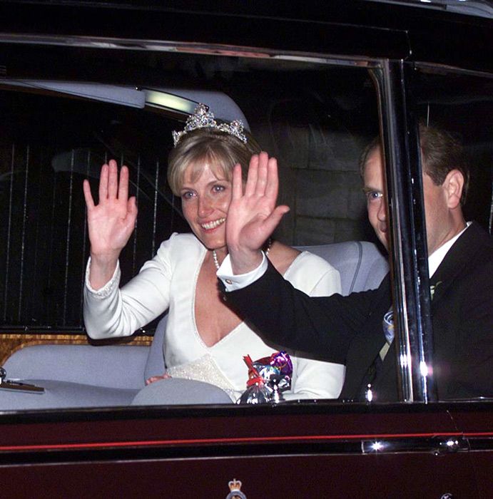 sophie edward waving in their car following their wedding reception