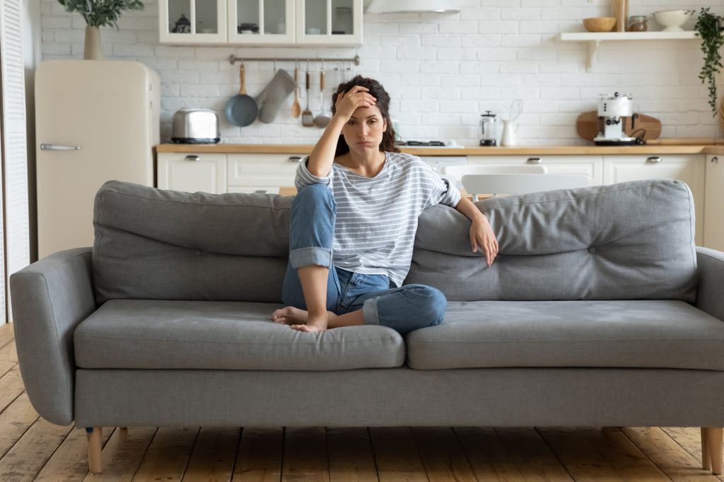 Woman looking miserable on her sofa