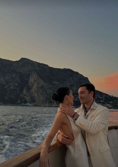 Ed Westwick holds Amy Jackson on a boat - both wearing all-white outfits