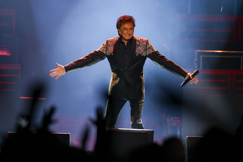 Barry Manilow partage une mise à jour « très déprimante » sur sa santé alors qu'il est obligé d'annuler davantage de spectacles alors qu'il se rétablit d'un cancer 1 photo de Barry Manilow tenant un micro sur scène
