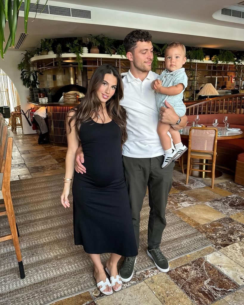 Sophia in black dress in bar with Frankie holding baby