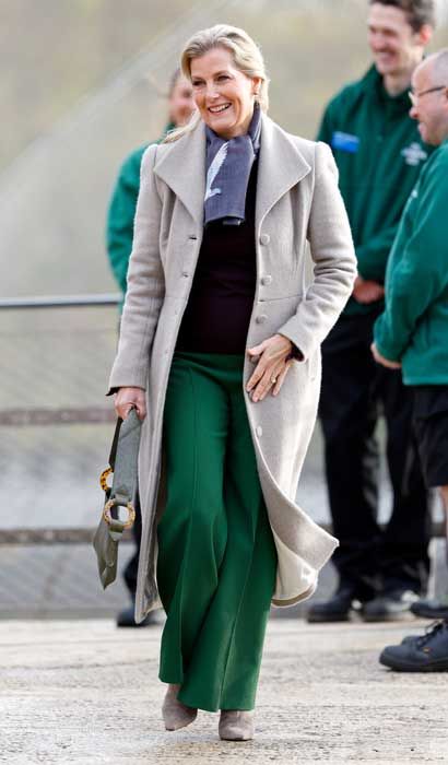 sophie wessex wearing green trousers and a grey coat smiling outside