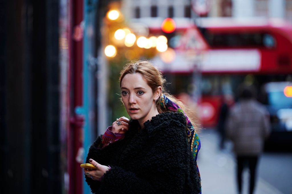 young woman standing on city pavement